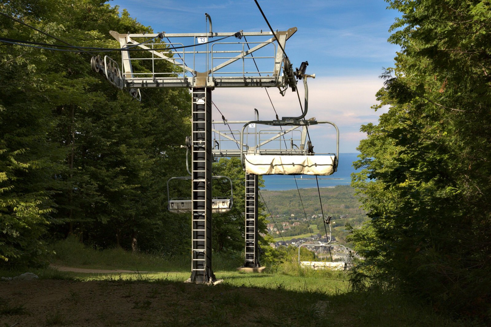 View of a ski lift in Blue Mountain, Ontario amidst lush greenery.
